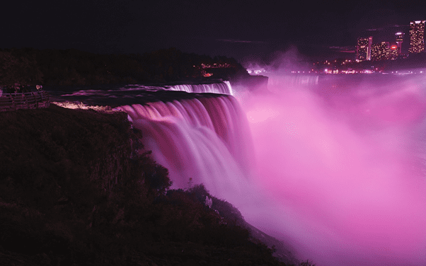 Niagara Falls at night with spray lit pink