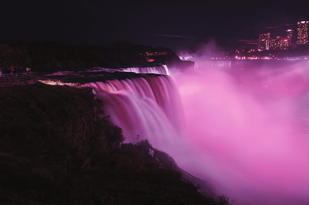 Niagara Falls at night with spray lit pink