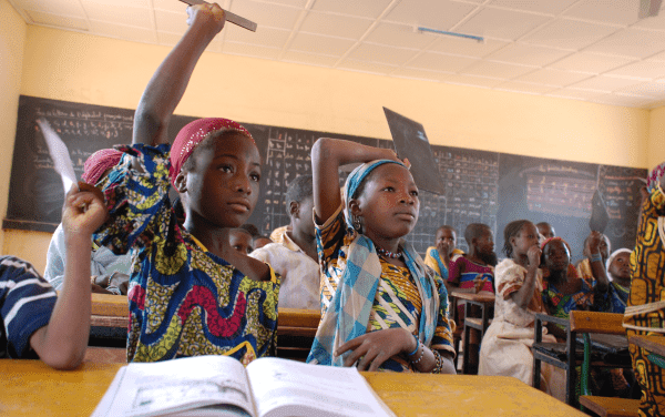 Girls in class with raised hands in Niger