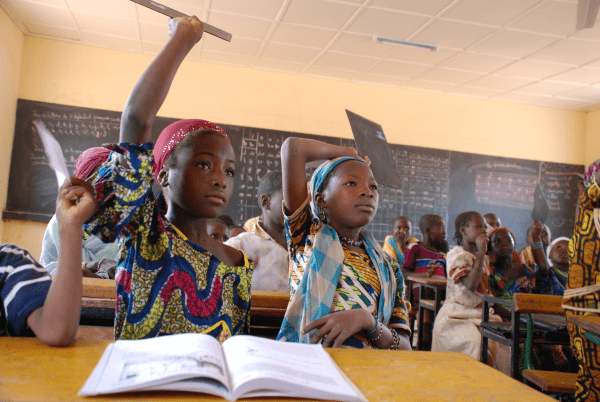 Girls in class with raised hands in Niger