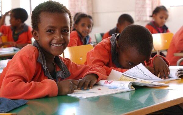 Children in class wearing orange uniform