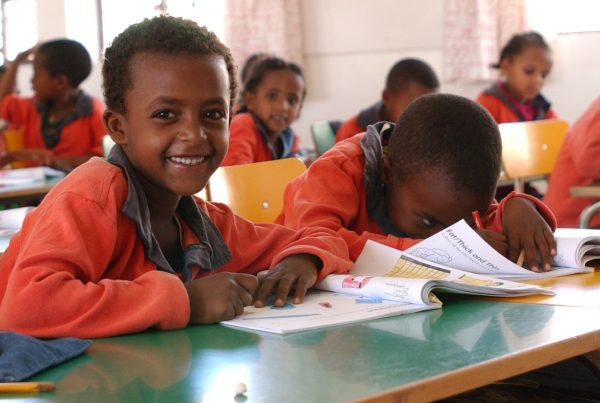 Children in class wearing orange uniform