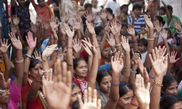 A large group of women with their hands raised