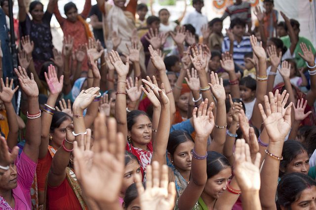 A large group of women with their hands raised