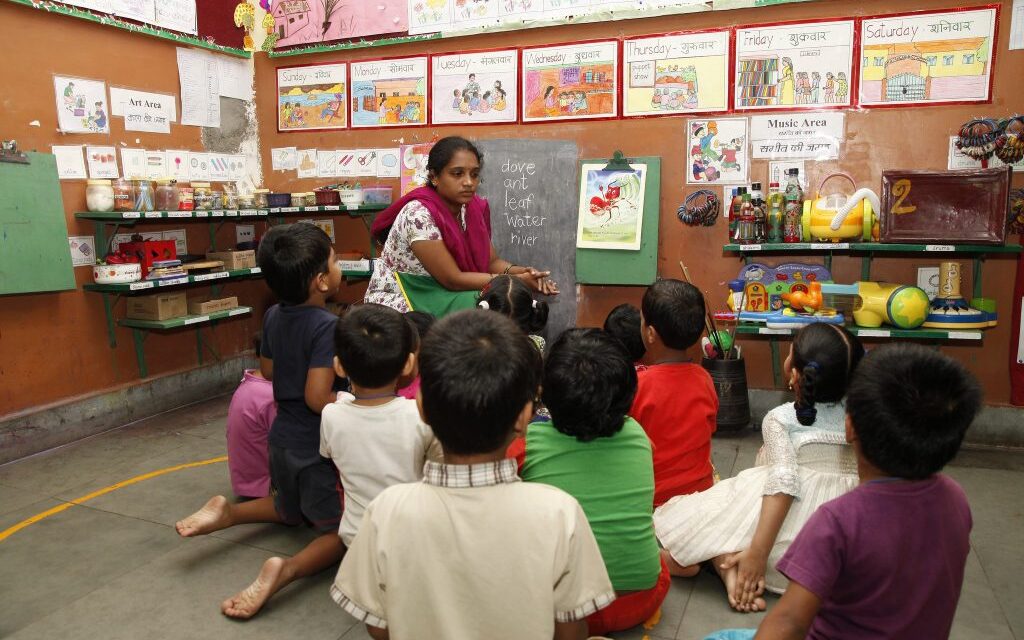 A teacher and children in class in India