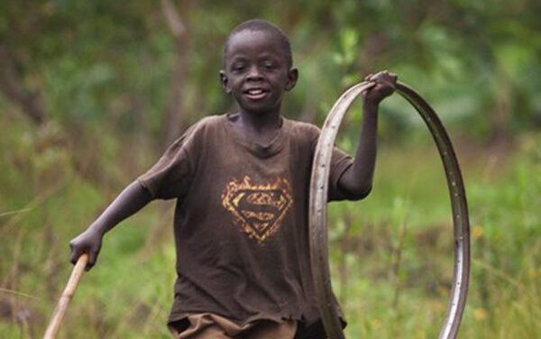 boy playing with bike wheel rim as hoop
