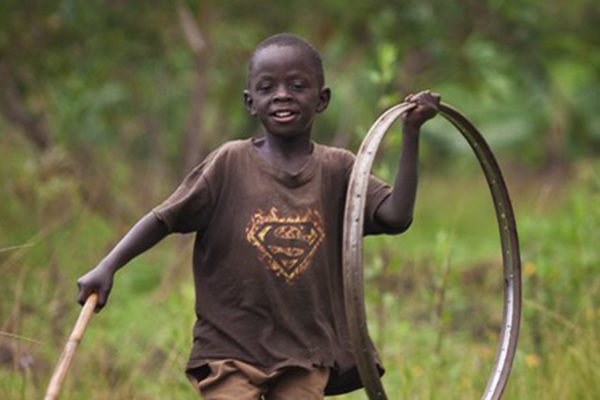 boy playing with bike wheel rim as hoop