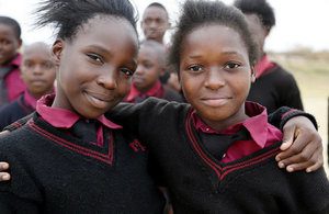 Two school girls with their arm around each other's shoulders