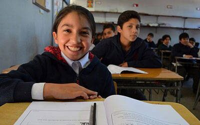 smiling child sitting at a school desk