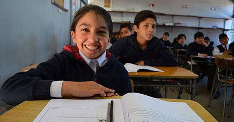 smiling child sitting at a school desk