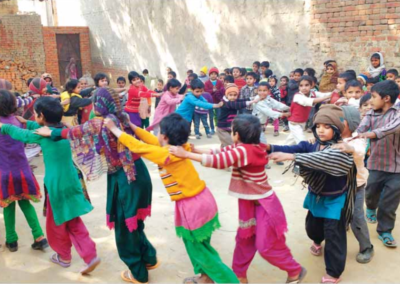 Children playing in a ring with their hands on the shoulders of the child in front