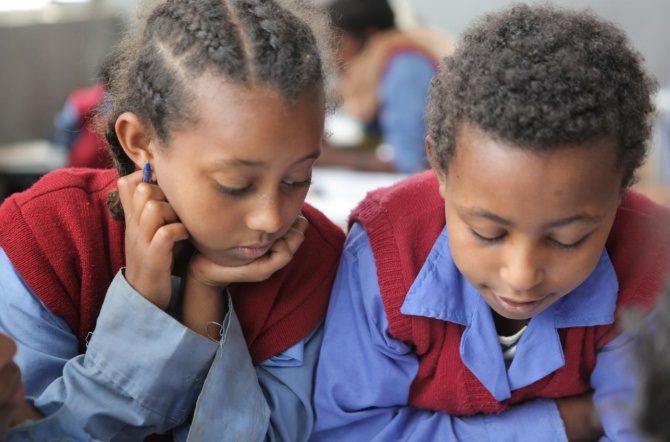 Two girls reading in a class in Ethiopia