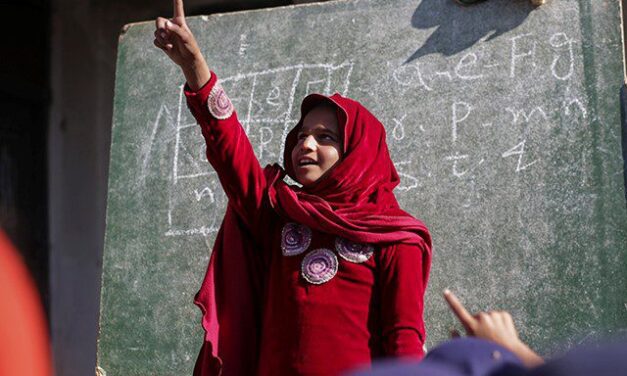 Girl dressed in red pointing upwards