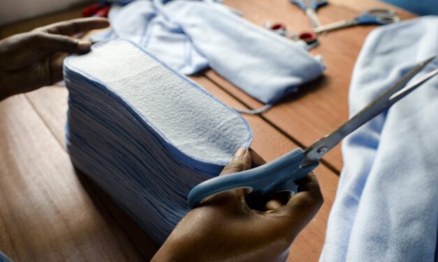 making sanitary products - a hand scissors and fabric