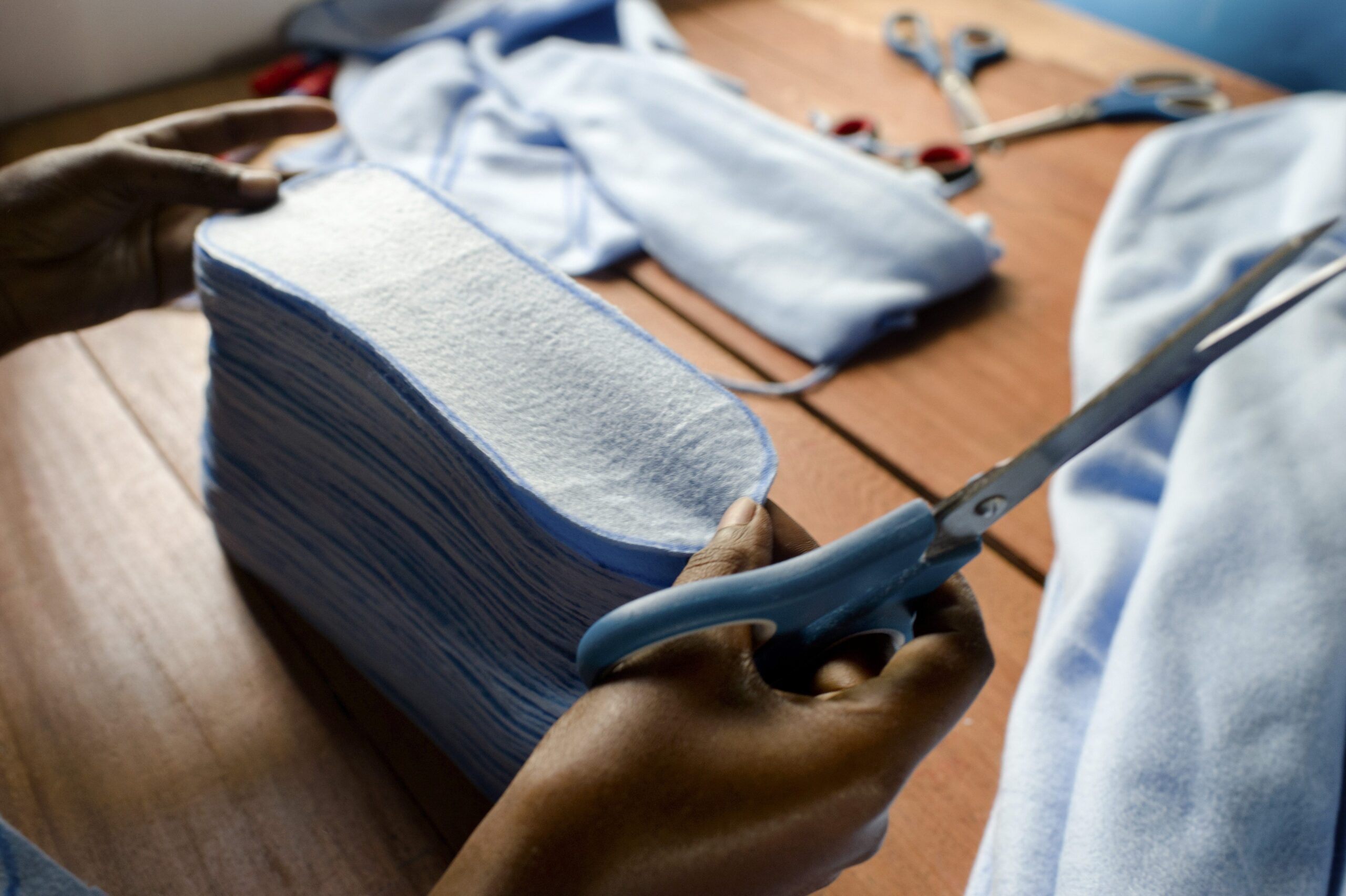 making sanitary products - a hand scissors and fabric