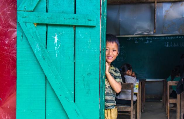 Boy looking out from the doorway of a classroom