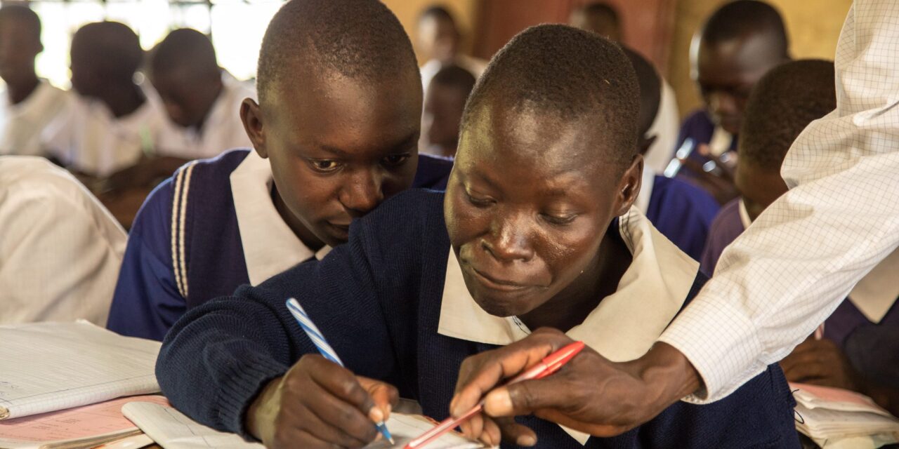 Teacher supporting boys in class