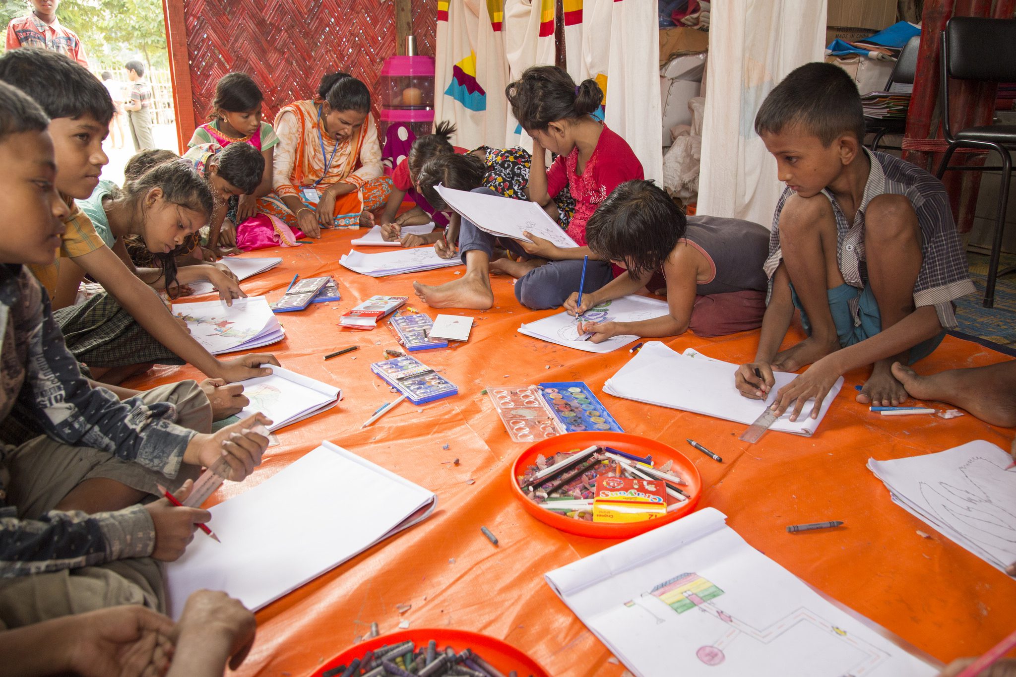 Children sitting on the floor in an art class