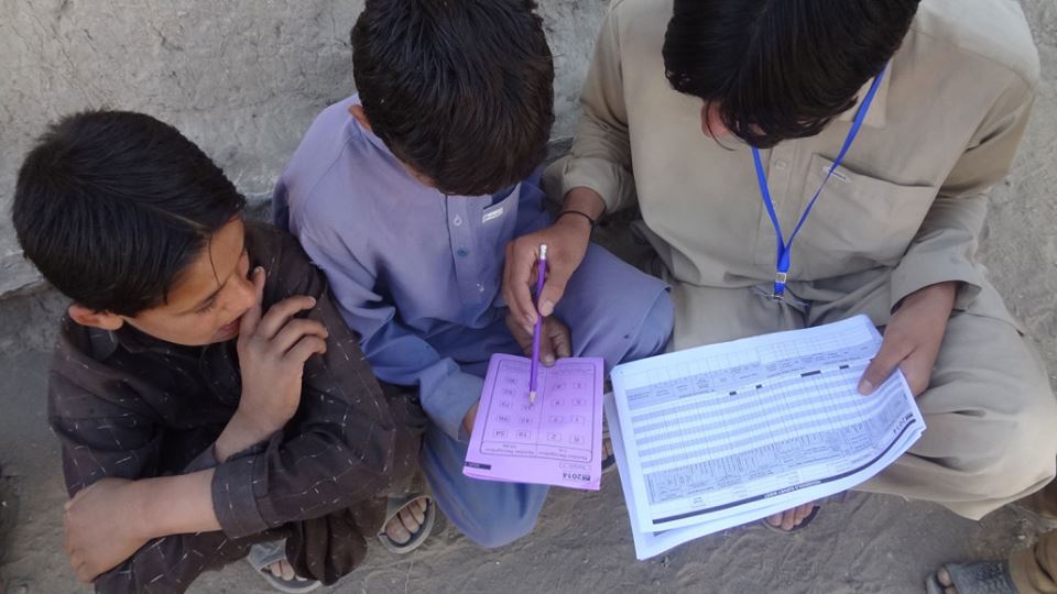 Teacher supporting two boy pupils