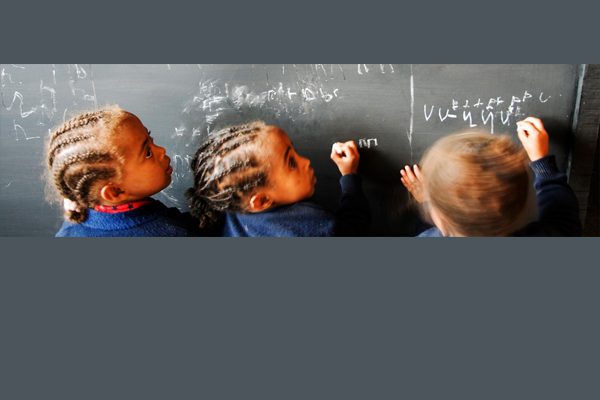Primary children writing on a blackboard