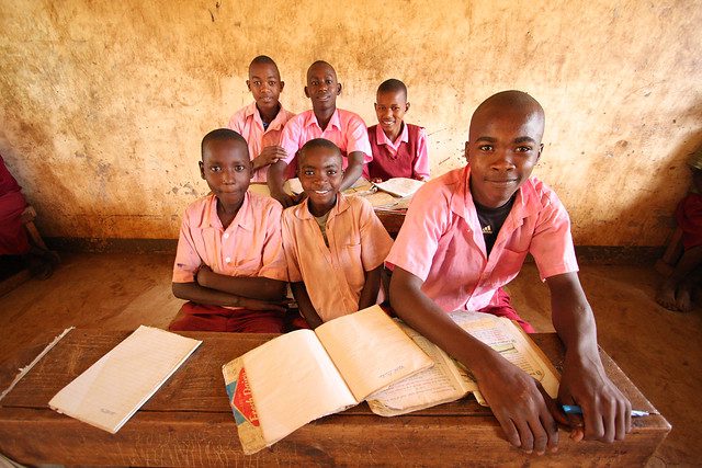 Children in a class at desks with books