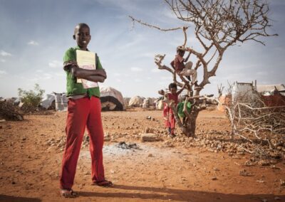 Ibrahim Hassan Ahmed, 14, standing in front of a tree