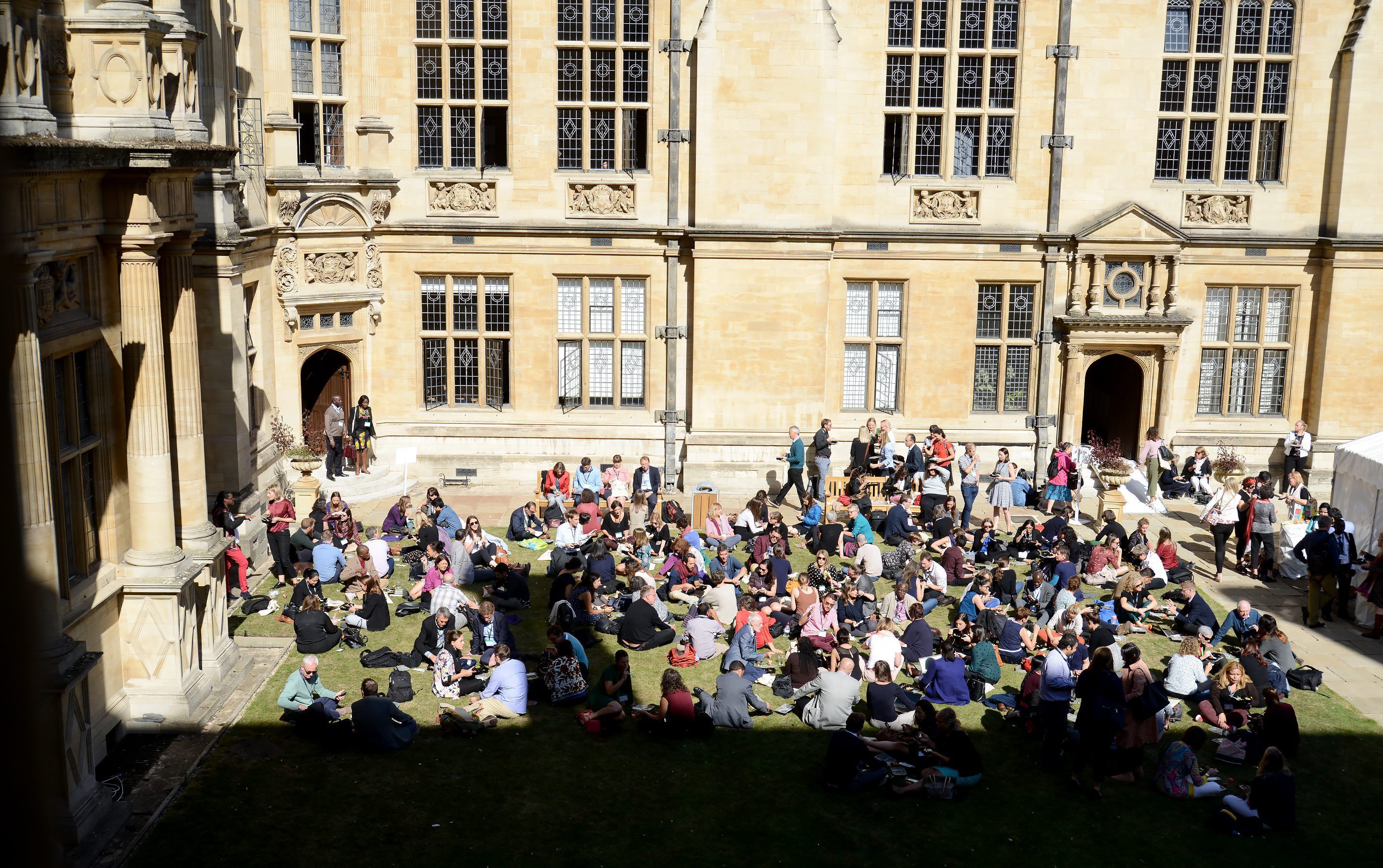 Conference delegates enjoying the sun in the Exam School Quad at lunchtime