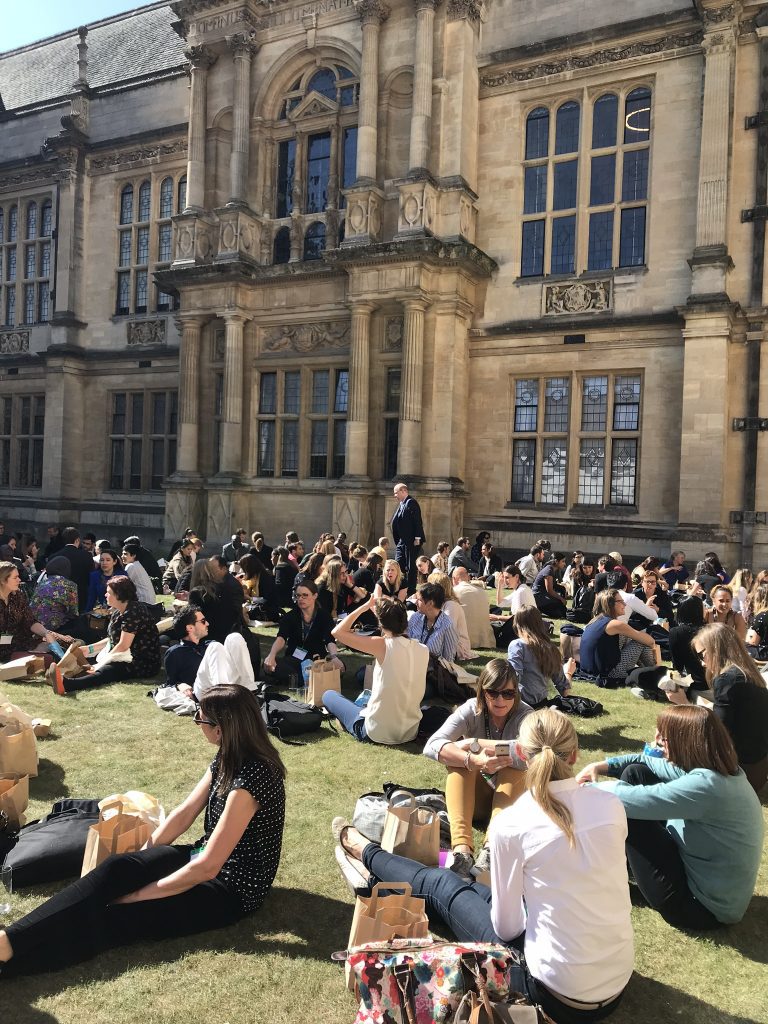2019 conference delegates sitting on the grass of the Quad at Examination Schools at lunchtime