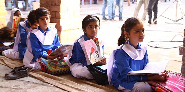 female primary school children sitting on the ground