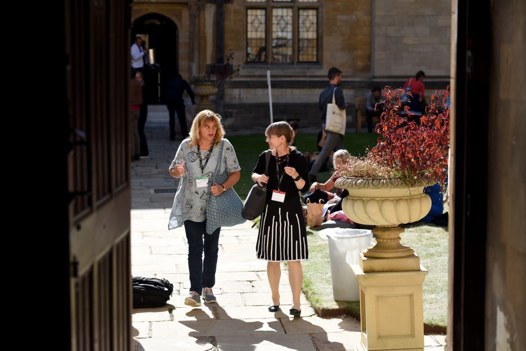 Delegates in conversation, walking across the quod at the Examination  Schools