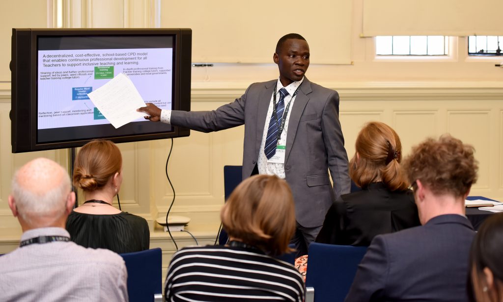 Presenter pointing to a screen at the conference