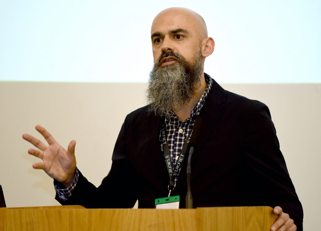 A male presenter at the conference