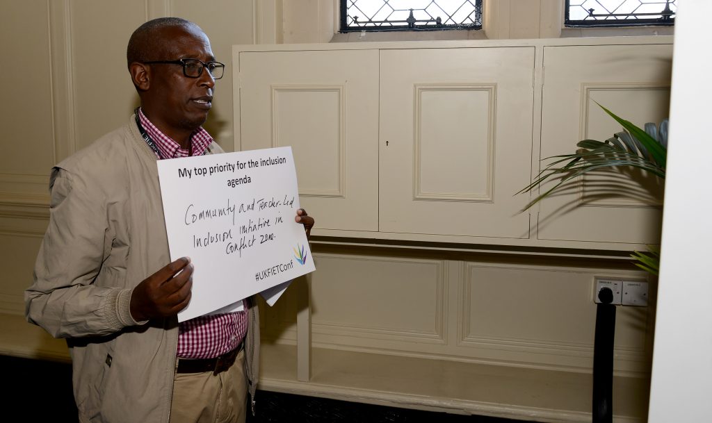 Jean Paul Rubyagiza Rubagira holds up a card My top priority for the inclusion agenda: Community and teacher-led inclusion initiative in conflict zone