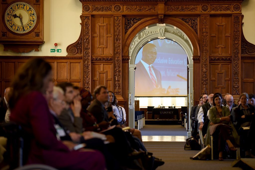 View of screen through an open doorway with Hon. Dr. Yaw Osei Adutwum Deputy Minister of Education, Ghana speaking in opening plenary 2019