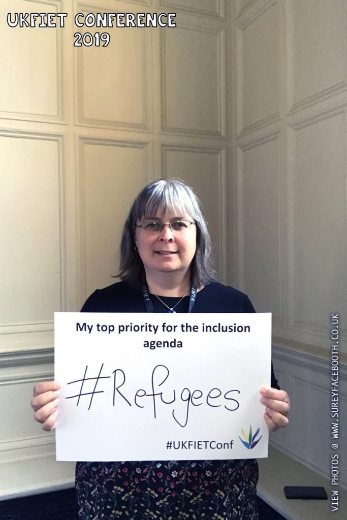 Sandra Baxter holds up a card My top priority for the inclusion agenda: #Refugees