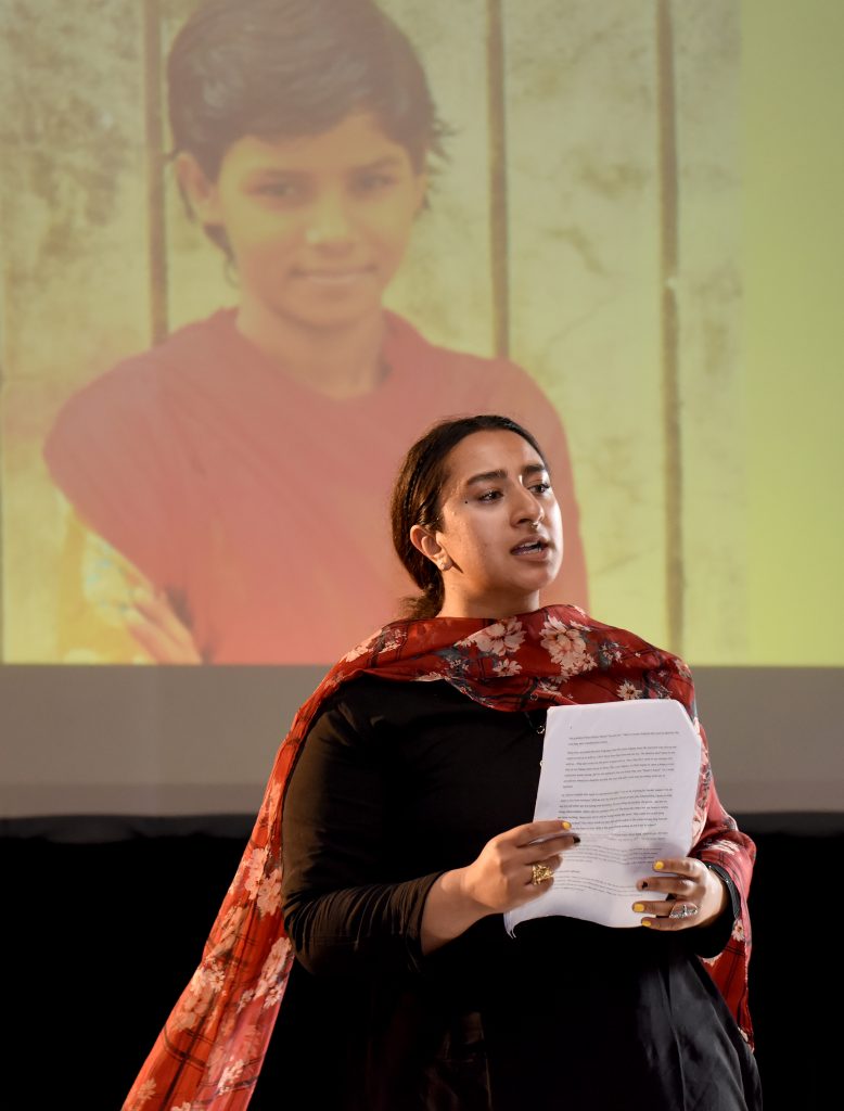 A female actor reading a letter to the Minister of Education