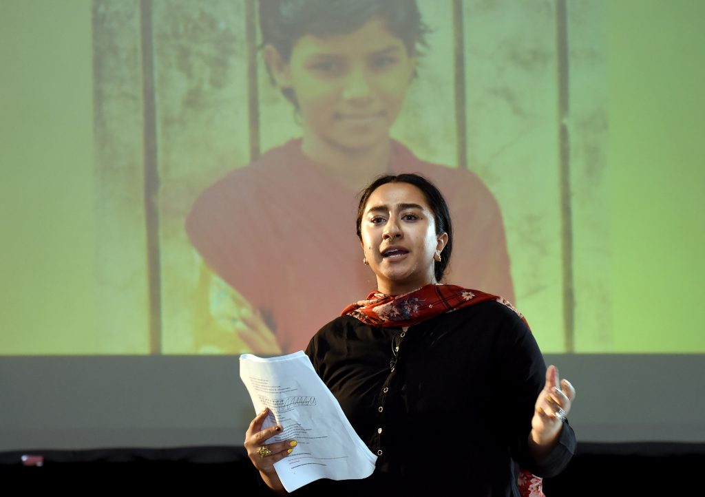 A female actor reading a letter to the Minister of Education