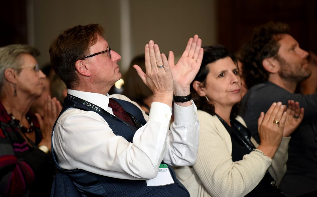Male delegate clapping at the 2019 BAICE Plenary