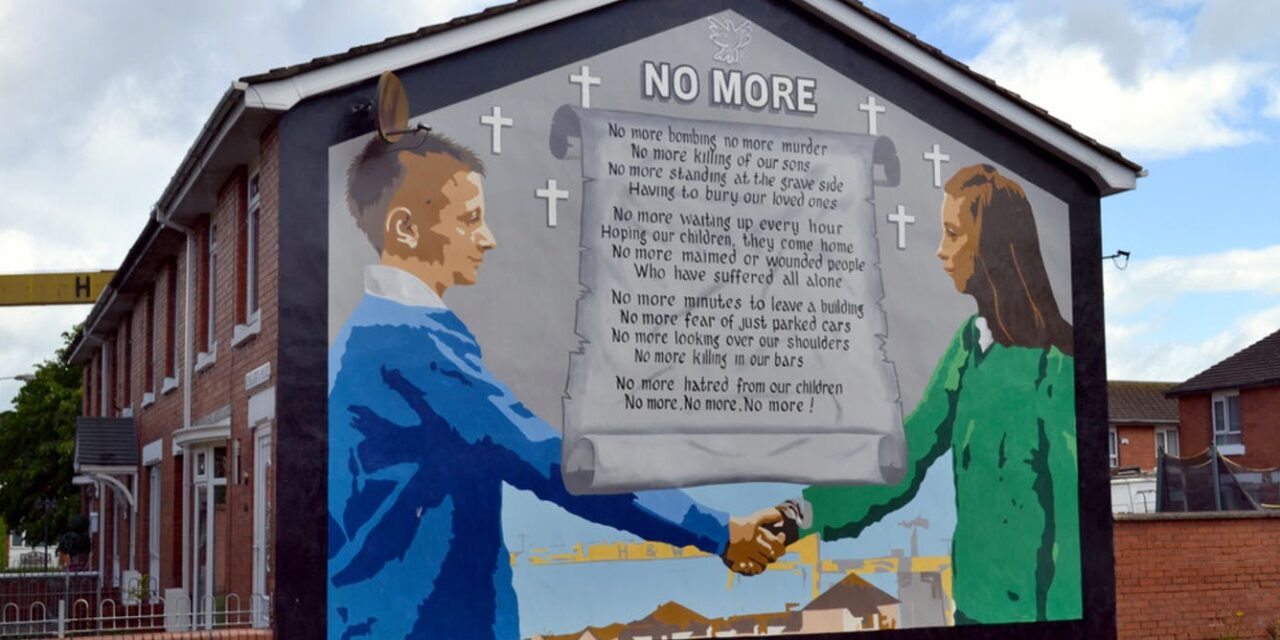 Mural on the end of a building of boys shaking hands across a letter entitled NO MORE