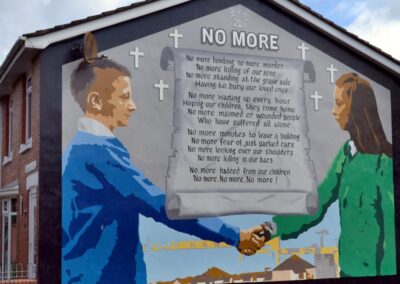 Mural on the end of a building of boys shaking hands across a letter entitled NO MORE