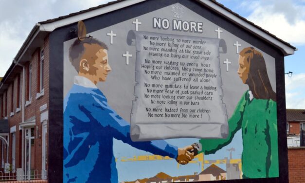 Mural on the end of a building of boys shaking hands across a letter entitled NO MORE