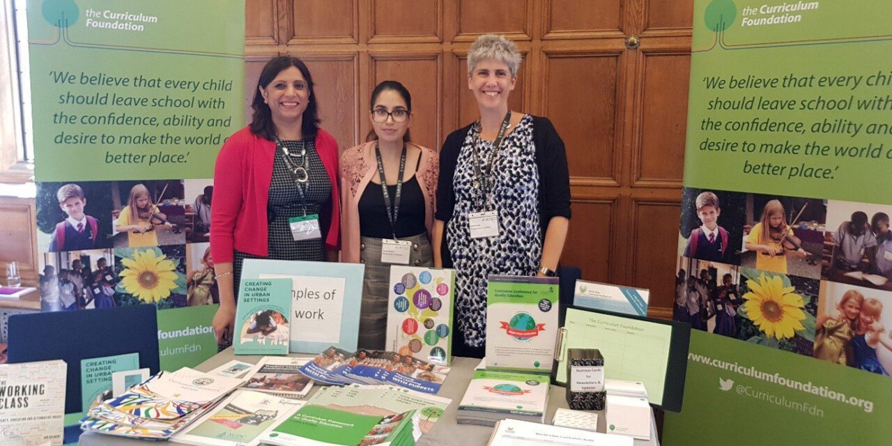 Curriculum Foundation exhibition stand at UKFIET Conference with three stand members