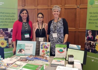 Curriculum Foundation exhibition stand at UKFIET Conference with three stand members