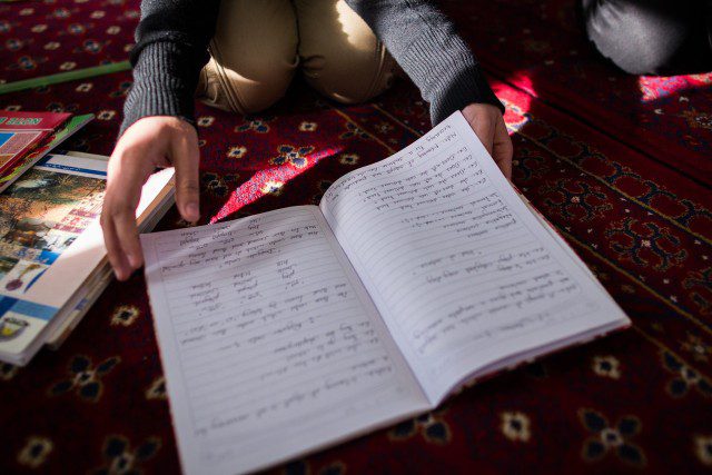 School book and child's hands