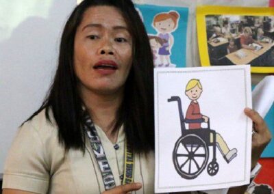 teacher holding up a picture of a child in a wheelchair