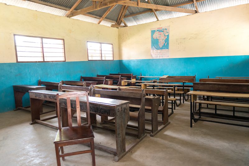 simple class room in village school with wooden desks and chairs in Zanzibar, Africa  The classroom is empty