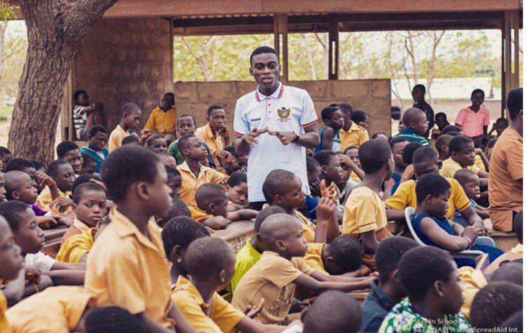 Teacher in outside classroom in Ghana