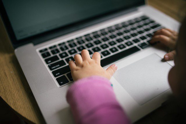 Child's hands on a laptop keyboard