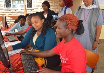 Students working on computers with helpers