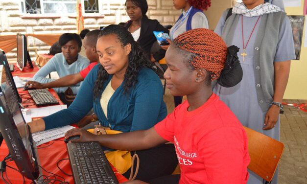 Students working on computers with helpers